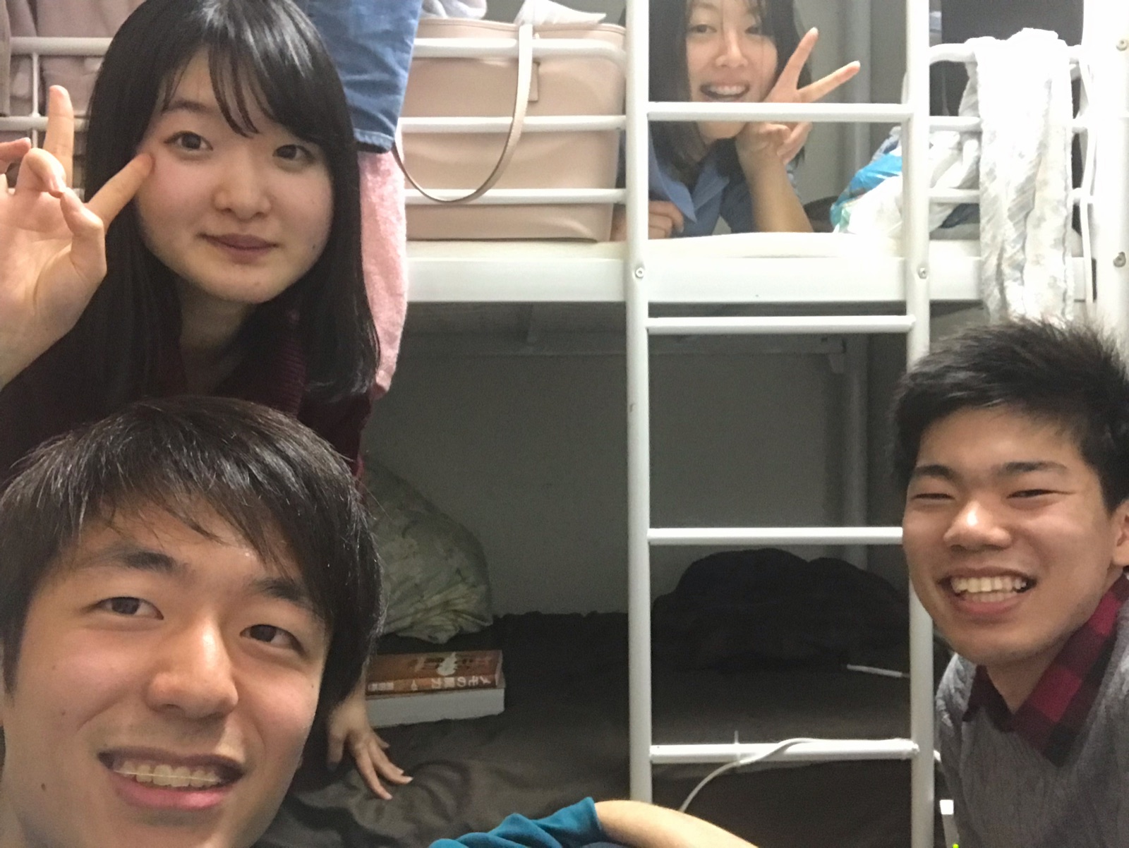 二段ベッドの上からピースサインをする2人